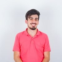 young male in pink t-shirt looking at camera and looking happy , front view.